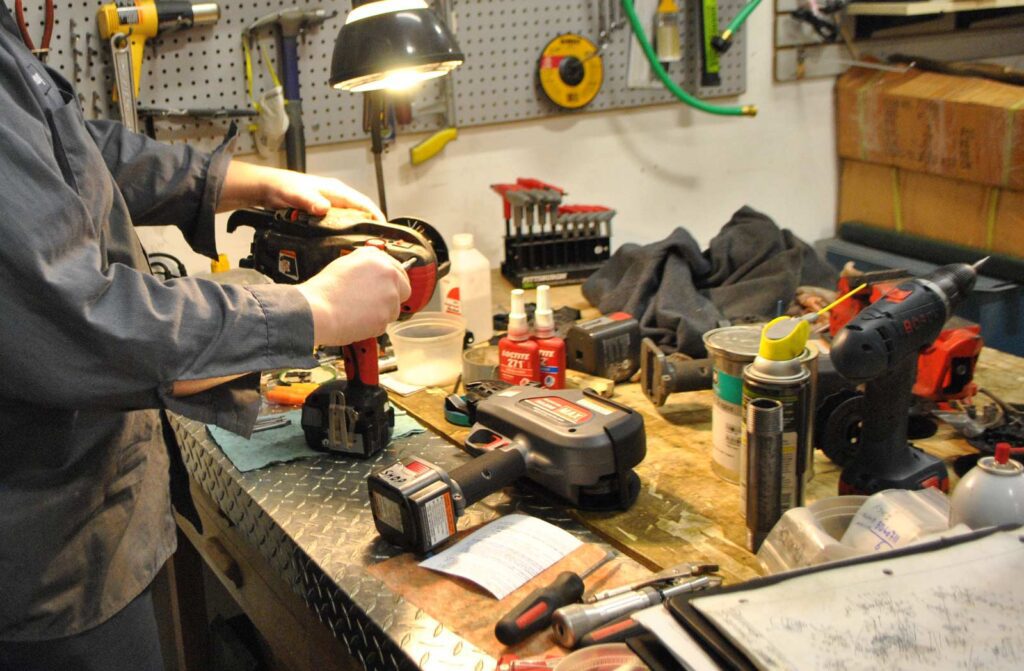 Technician Repairing Power Tools at a Workshop Bench – Fully Tested & Certified Repairs
