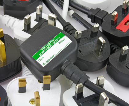 an assortment of UK standard three pin plugs on a bench